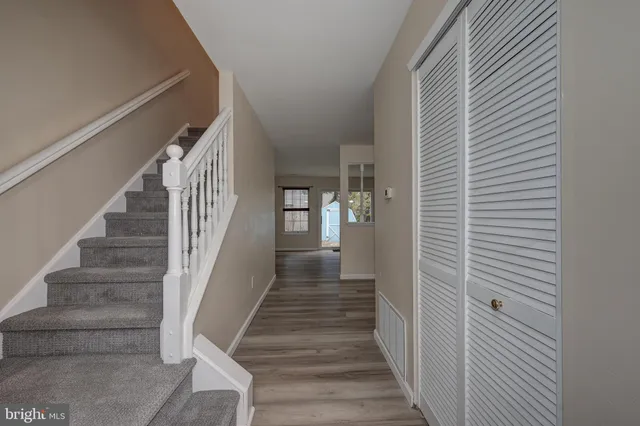 a view of a hallway with wooden floor and staircase