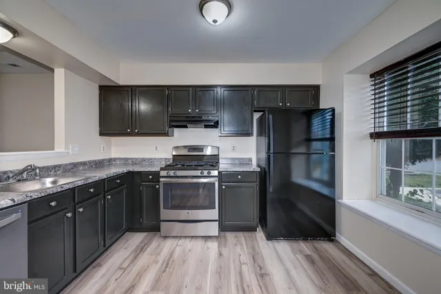 a kitchen with stainless steel appliances granite countertop a refrigerator and a sink
