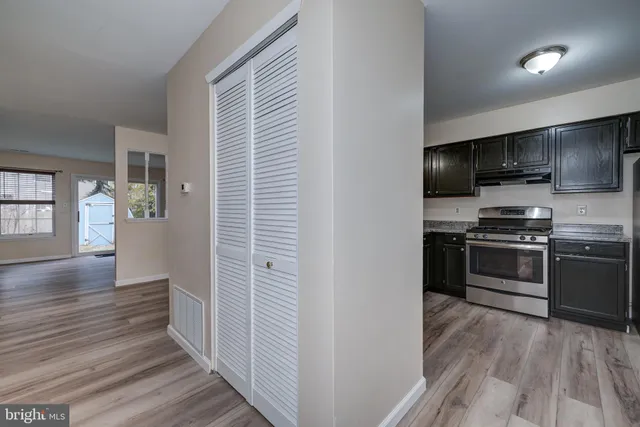 a kitchen with a refrigerator and a stove top oven