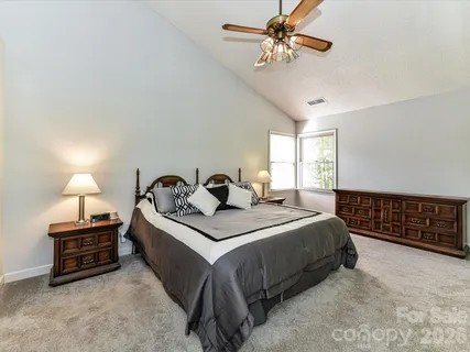 a spacious bedroom with a bed and a ceiling fan