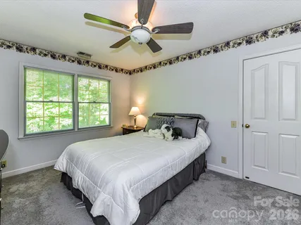 a bedroom with a bed and a ceiling fan