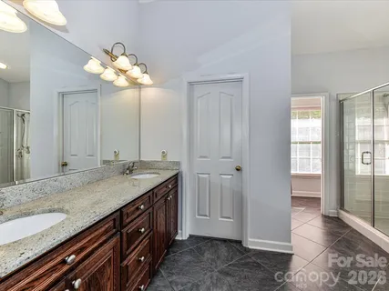 a bathroom with a granite countertop sink and a mirror