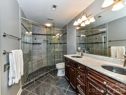 a bathroom with a sink a toilet and shower