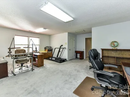 a view of a workspace with furniture and a window
