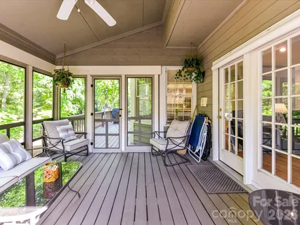 a balcony with wooden floor table and chairs