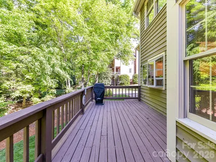 a view of a wooden balcony with trees