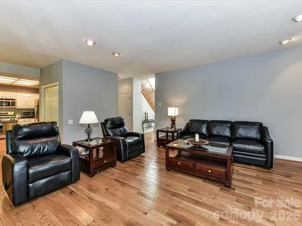 a living room with furniture a wooden floor and a piano
