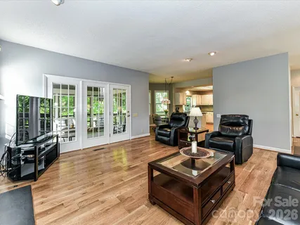 a living room with furniture a flat screen tv and a large window