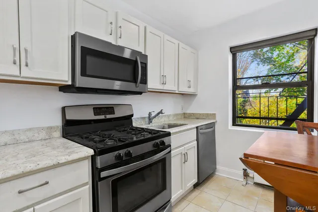 a kitchen with stainless steel appliances granite countertop a stove and a microwave