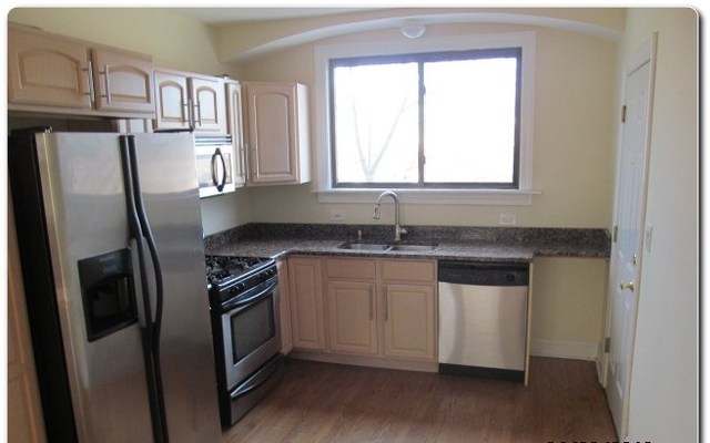 5655 North Spaulding Avenue, Unit 2W Chicago, IL 60659 - Photo 3 of 13 a kitchen with stainless steel appliances granite countertop a refrigerator a sink and white cabinets