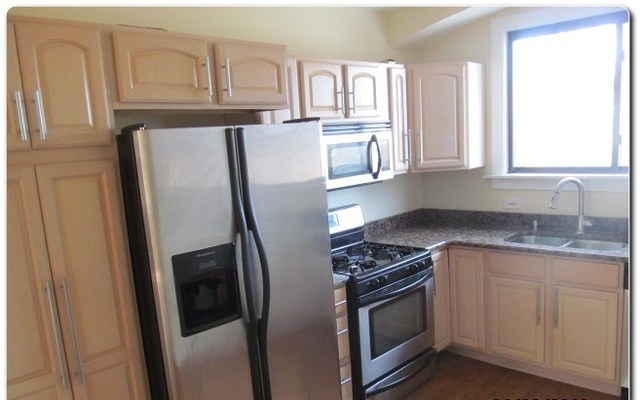 5655 North Spaulding Avenue, Unit 2W Chicago, IL 60659 - Photo 4 of 13 a kitchen with granite countertop a refrigerator stove and sink