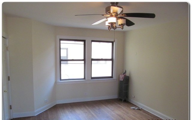 5655 North Spaulding Avenue, Unit 2W Chicago, IL 60659 - Photo 7 of 13 an empty room with a window and a chandelier
