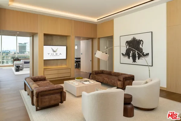 a living room with couches and a large window with garden view