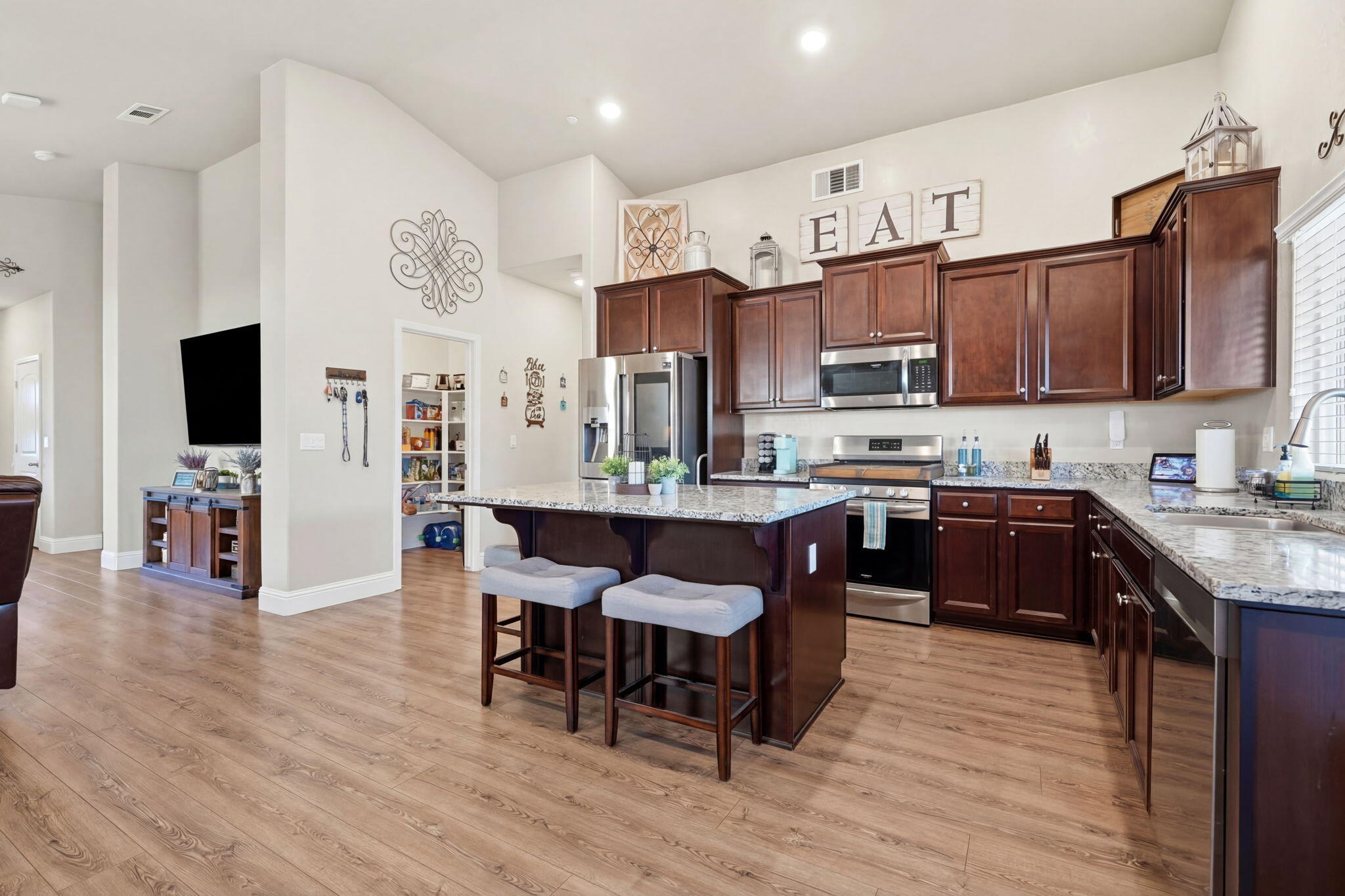 756 Strada Street Lemoore, CA 93245 - Photo 13 of 53 a large kitchen with cabinets wooden floor and stainless steel appliances