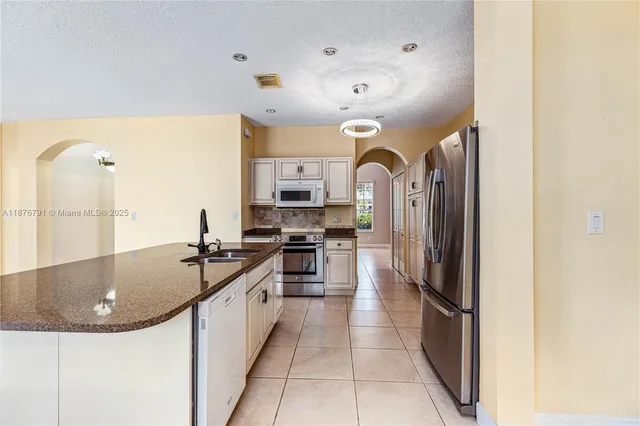 a kitchen with stainless steel appliances granite countertop a stove a sink and a refrigerator