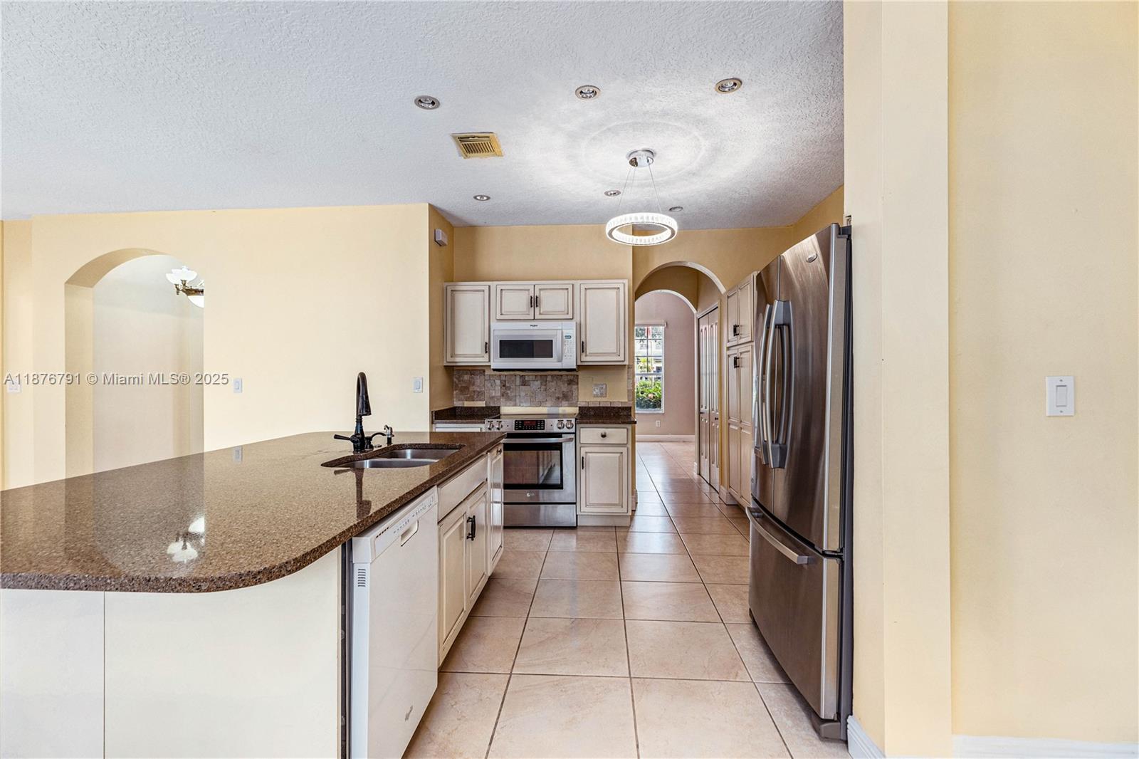 20235 Southwest 129th Avenue, Unit 20235 Miami, FL 33177 - Photo 12 of 35 a kitchen with stainless steel appliances granite countertop a sink and refrigerator