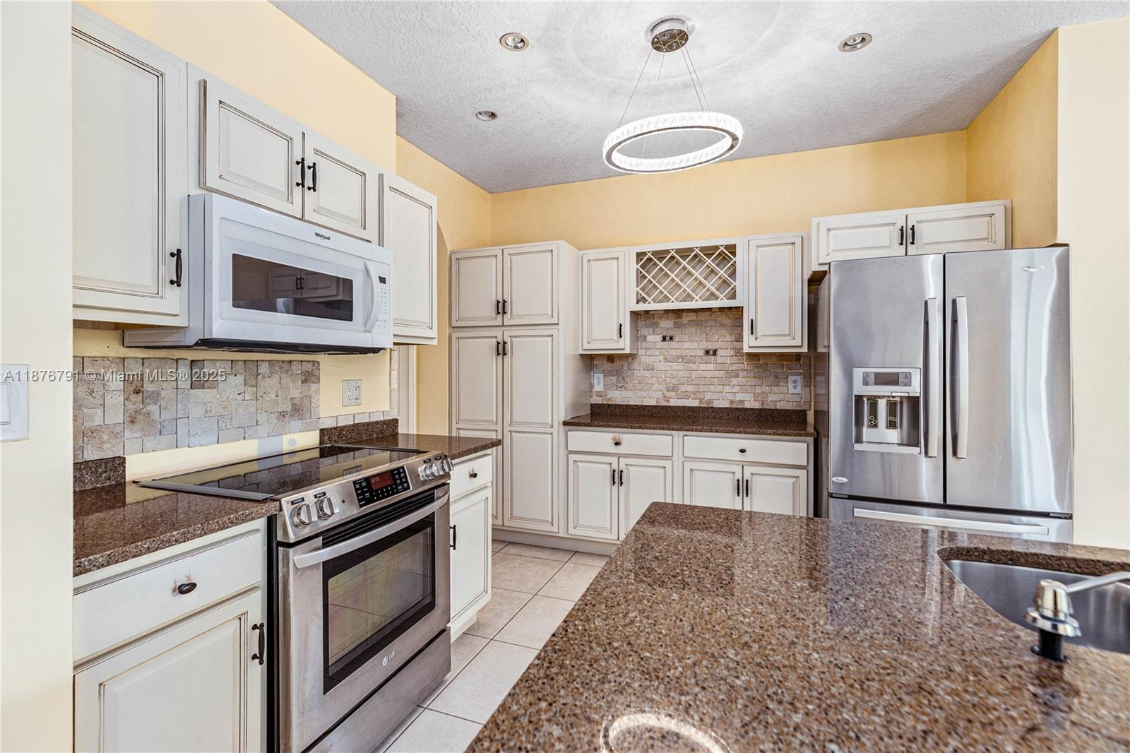 20235 Southwest 129th Avenue, Unit 20235 Miami, FL 33177 - Photo 14 of 35 a kitchen with stainless steel appliances granite countertop a stove a sink and a refrigerator