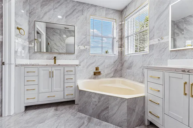 a bathroom with a tub sink and mirror