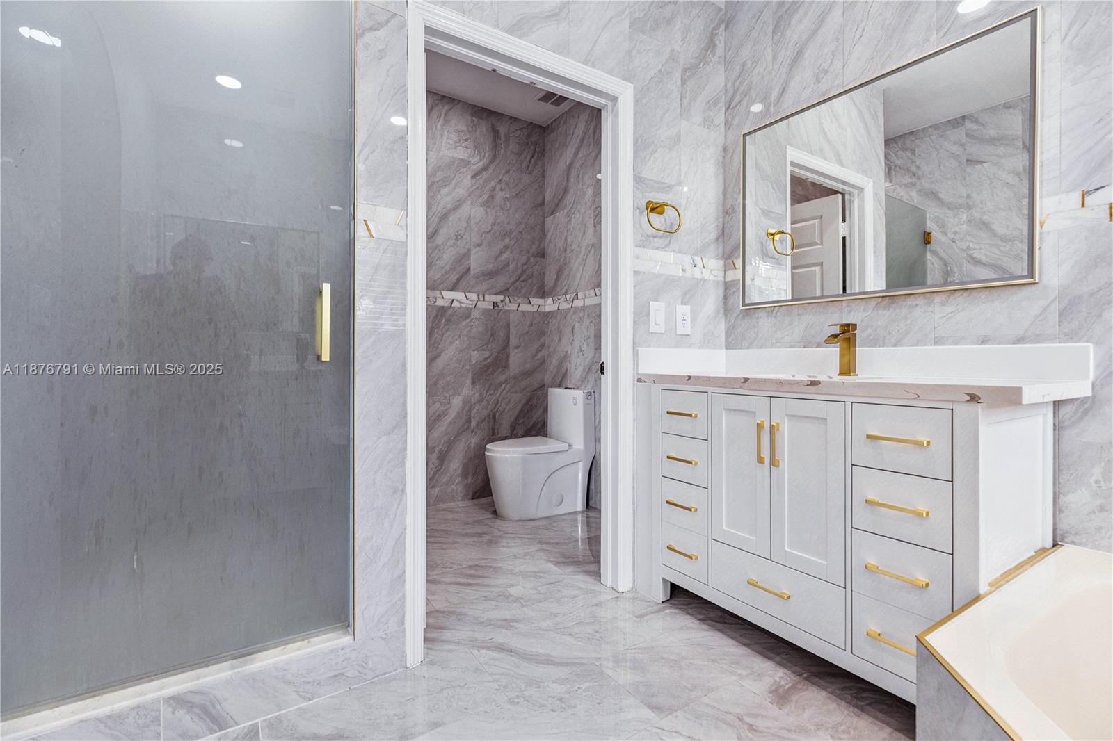 20235 Southwest 129th Avenue, Unit 20235 Miami, FL 33177 - Photo 23 of 35 a bathroom with a granite countertop sink a toilet and a mirror