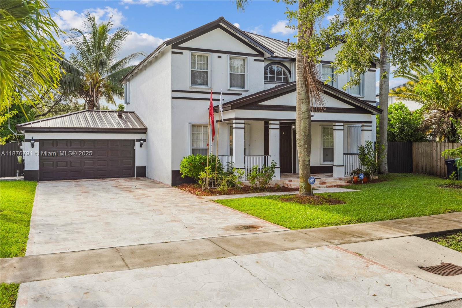 20235 Southwest 129th Avenue, Unit 20235 Miami, FL 33177 - Photo 4 of 35 a front view of a house with a yard and garage