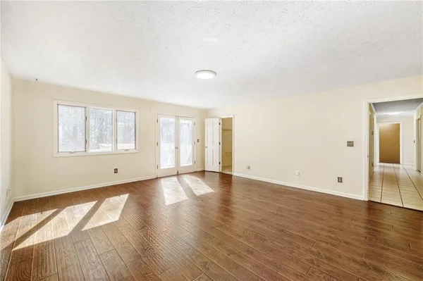 an empty room with wooden floor and windows