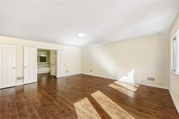 a view of empty room with wooden floor