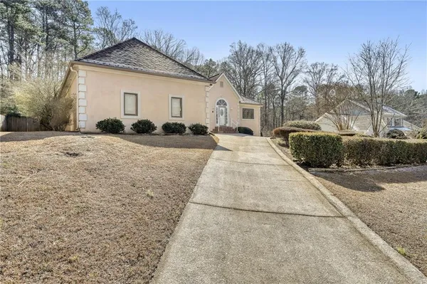 a view of a grey house with a yard