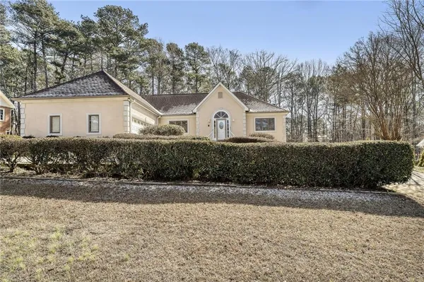 a front view of a house with a yard and trees