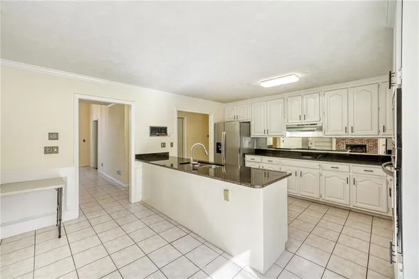 a large white kitchen with cabinets and a refrigerator