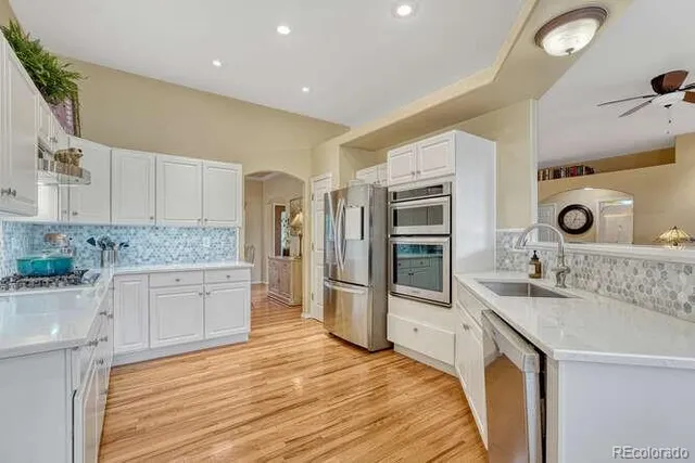 a kitchen with granite countertop white cabinets and stainless steel appliances