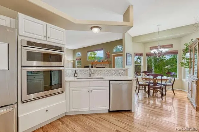 a kitchen with granite countertop white cabinets and white appliances