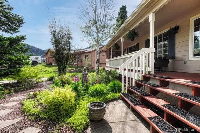 a view of a house with backyard and trees