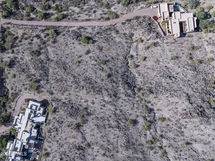 a view of a dry yard with wooden fence