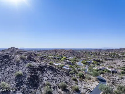 an aerial view of house with yard and mountain in the background