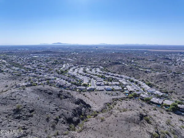 an aerial view of house with yard and mountain view in back