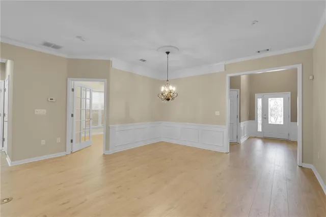 a view of an empty room with a kitchen and window