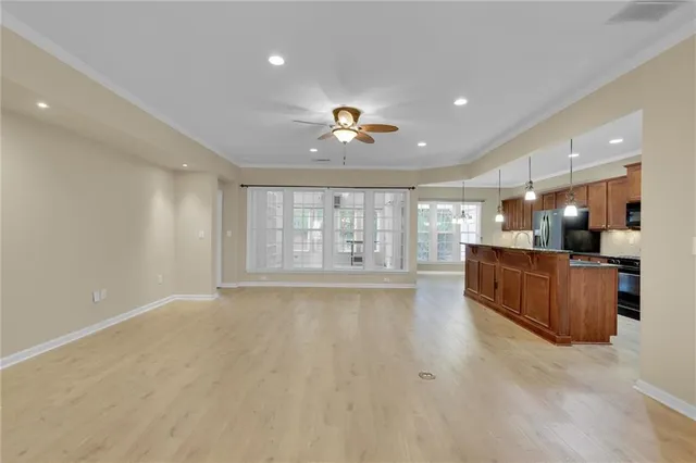 a kitchen with granite countertop a refrigerator oven a sink dishwasher and wooden cabinets with wooden floor