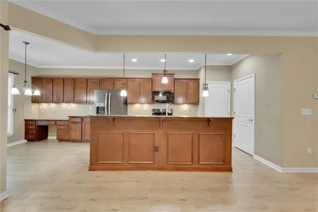 a kitchen with granite countertop stainless steel appliances and wooden cabinets