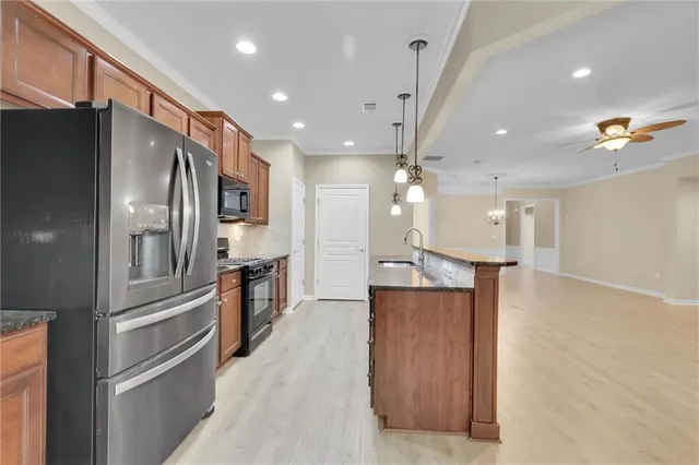 a view of an empty room with chandelier fan