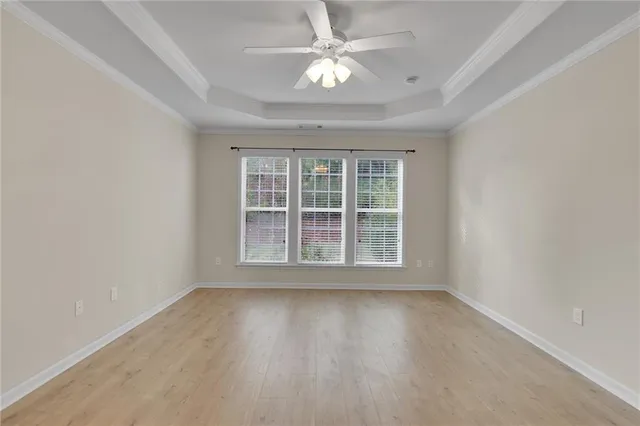a living room with furniture two windows and a ceiling fan