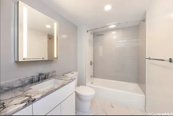 a bathroom with a granite countertop sink toilet and shower