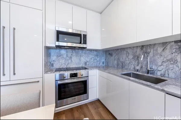 a kitchen with granite countertop a stove and a microwave
