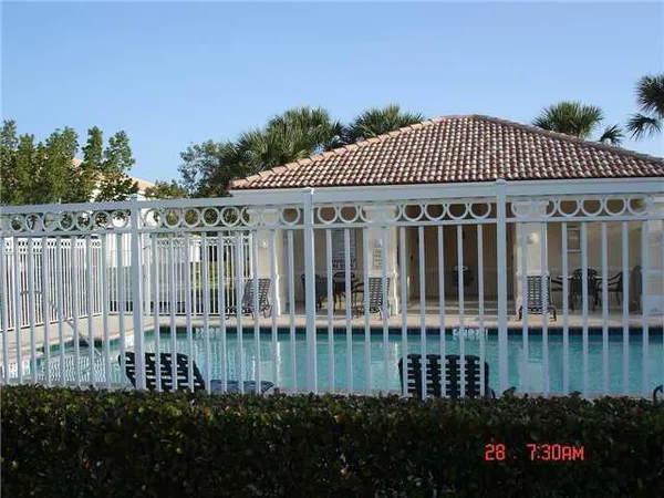 a view of white house with a big yard and palm trees