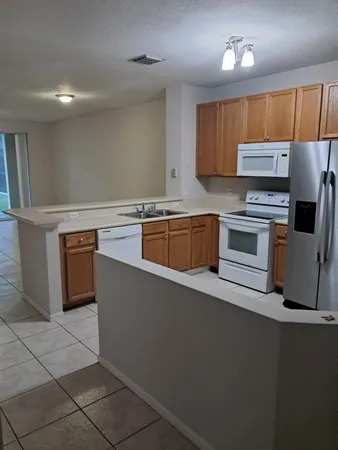 a kitchen with stainless steel appliances a stove a sink a microwave and a refrigerator