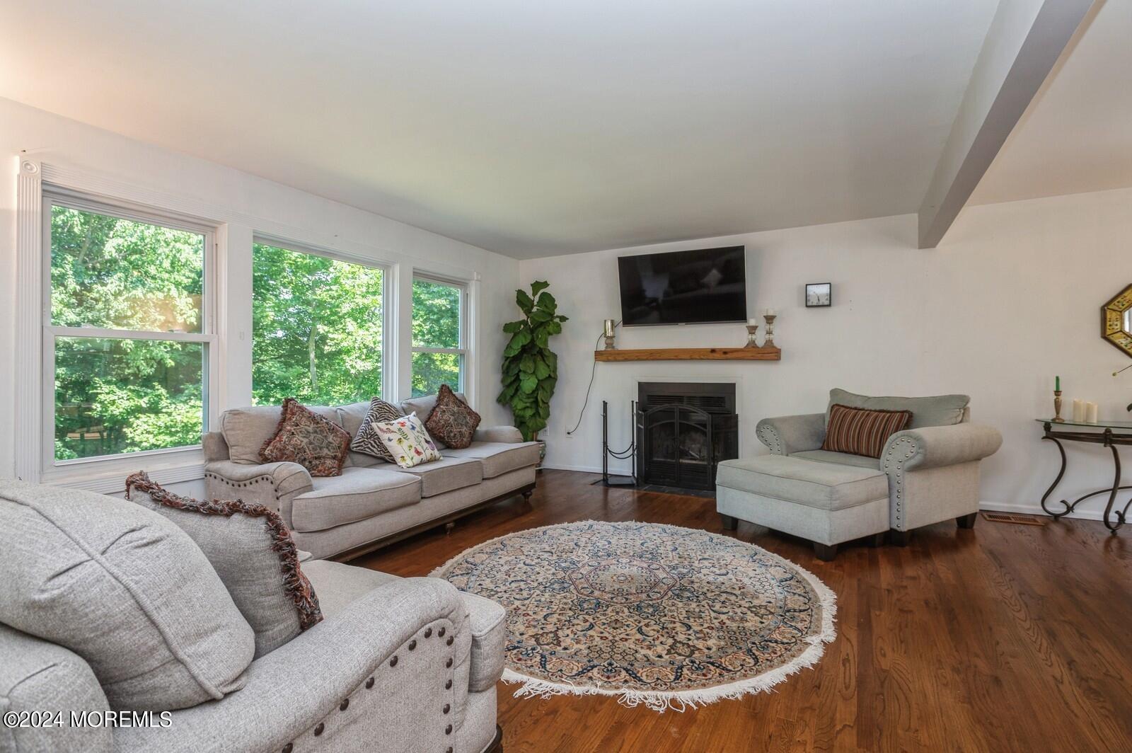 212 Nottingham Road Morganville, NJ 07751 - Photo 13 of 24 a living room with furniture a fireplace and a flat screen tv