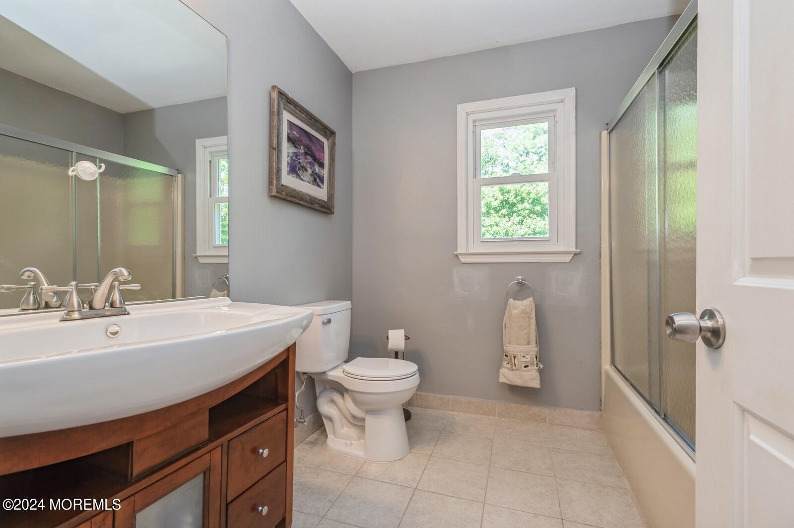 212 Nottingham Road Morganville, NJ 07751 - Photo 20 of 24 a bathroom with a sink a toilet a mirror and a window