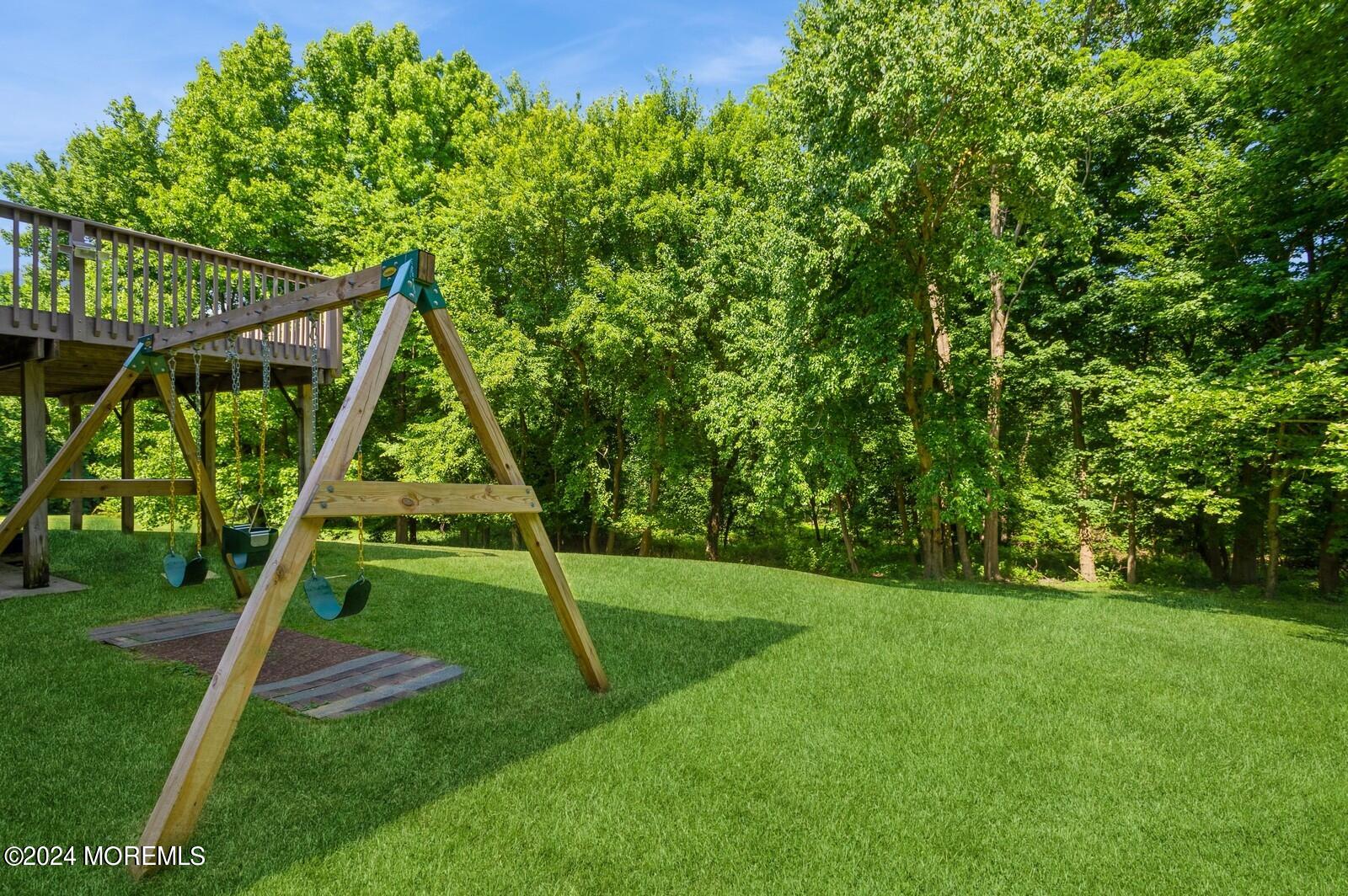 212 Nottingham Road Morganville, NJ 07751 - Photo 24 of 24 a view of a backyard with a slide and a child swing