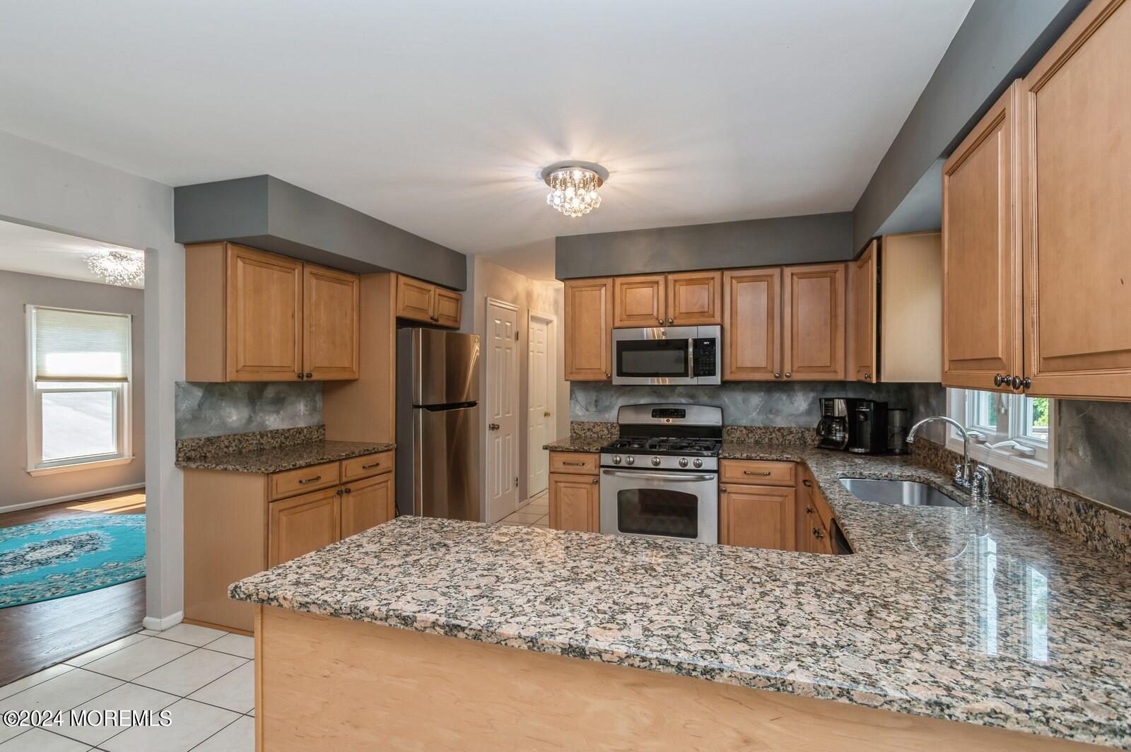 212 Nottingham Road Morganville, NJ 07751 - Photo 7 of 24 a kitchen with granite countertop a stove sink microwave and refrigerator