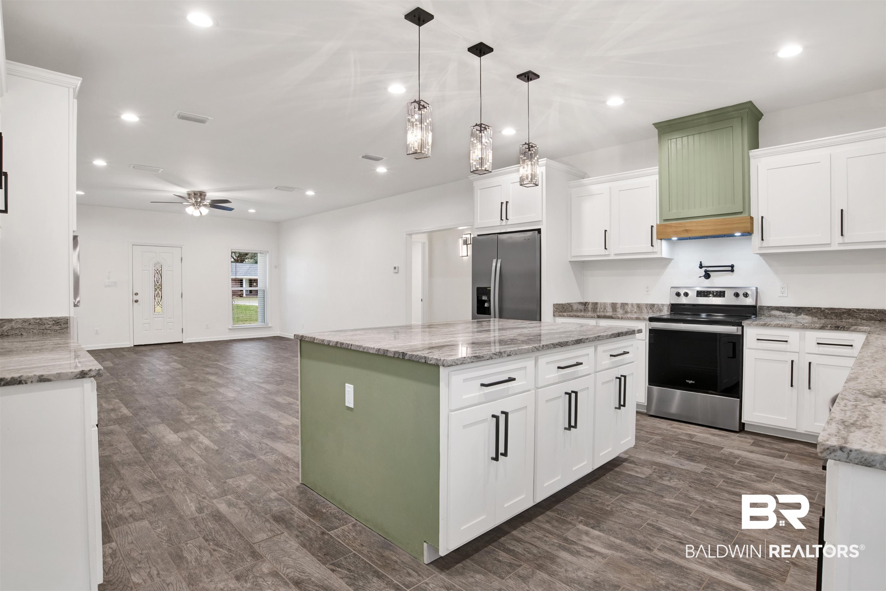 10871 Somerset Road Grand Bay, AL 36541 - Photo 13 of 31 Kitchen with appliances with stainless steel finishes, a kitchen island, decorative light fixtures, and white cabinets