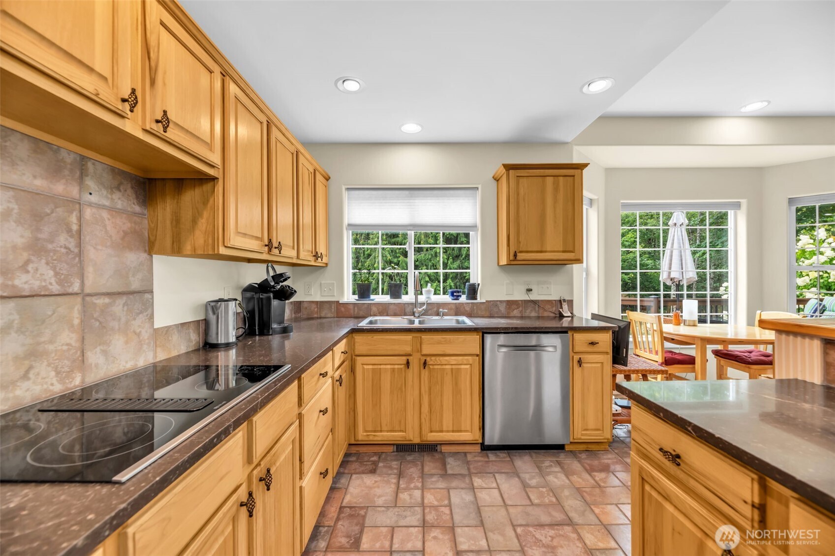 18005 252nd Avenue Southeast Maple Valley, WA 98038 - Photo 5 of 40 a kitchen with stainless steel appliances granite countertop wooden cabinets a stove a sink and a large window